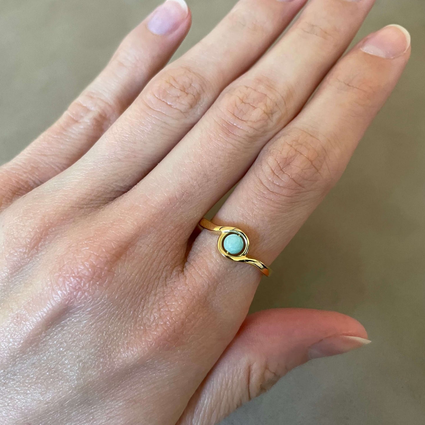 Close-up of a gold Arise amazonite fidget ring with a minimal and calming design