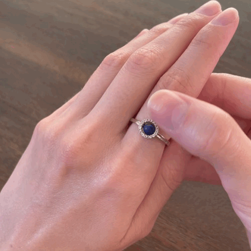 Animated spinning Enchant blue lapis fidget ring in silver with a white topaz gemstone halo for anxiety relief, showcasing its movement