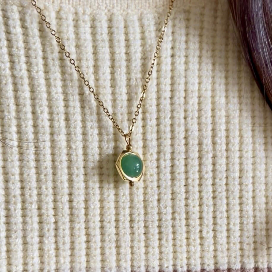 Close-up of the dainty Grace green aventurine fidget necklace in gold