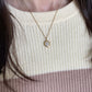 A Luna moonstone fidget necklace in gold worn with the pearl fidget ring