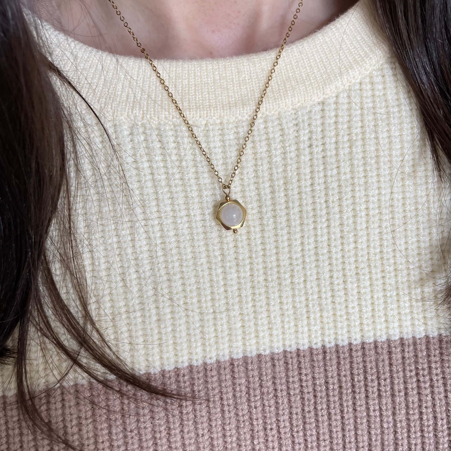 A Luna moonstone fidget necklace in gold worn with the pearl fidget ring